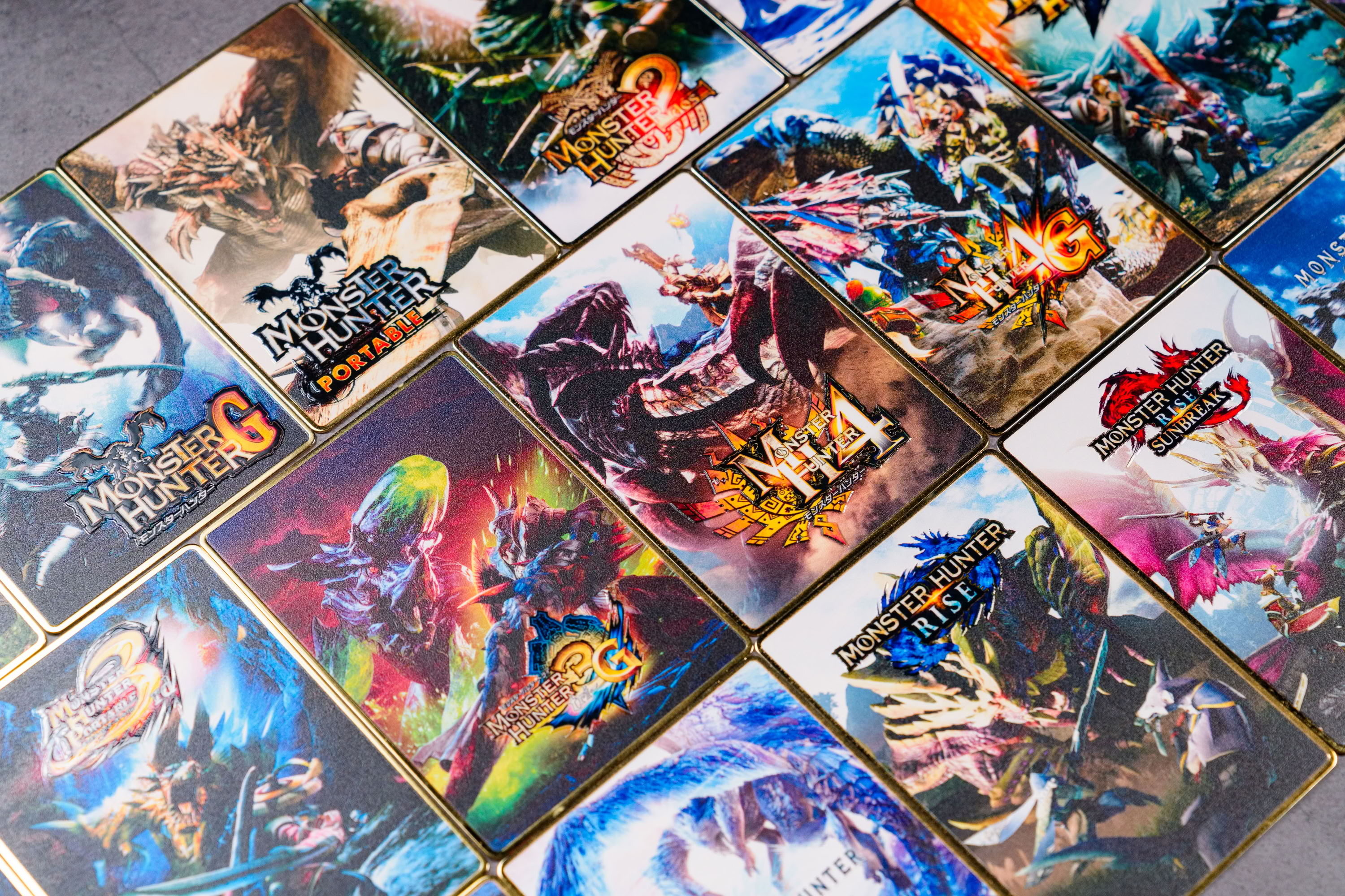 MONSTER HUNTER 金屬卡牌，展示歷代主視覺與金色金屬邊緣
